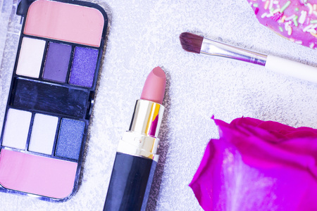 Make Up Beauty Fashion Business Concept. Nude lipstick, eyeshadow palette and a pink rose on a white stone background, top view, close upの写真素材