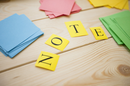 Education Creativity concept. Colorful stick notes and NOTE inscription on a light wooden background, top viewの写真素材