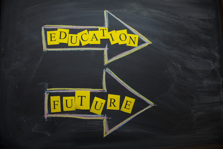 Education Creativity concept. EDUCATION and FUTURE arrows on a black board, top view, close upの写真素材