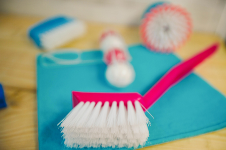 Cleaning house or office concept. A blue rag, brushes and toilet refreshing block on natural wooden background, close upの写真素材