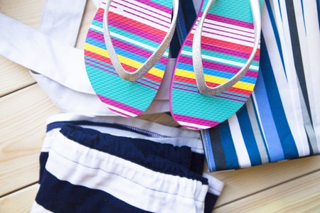 Preparing for vacation, travel or journey. Travel planning. Beach sleepers on white wooden background.の写真素材