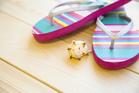 Preparing for vacation, travel or journey. Travel planning. Beach sleepers on white wooden background.の写真素材