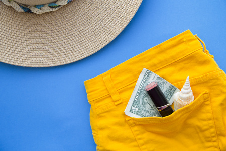 Preparing for vacation, travel or journey. Travel planning. Booking hotel. Yellow jeans on blue...
