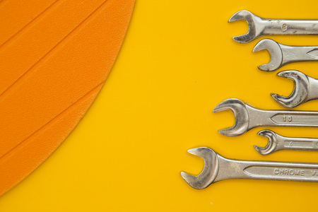 Repair and renovation concept. A set of metal tools for repair with wrench on a yellow background...