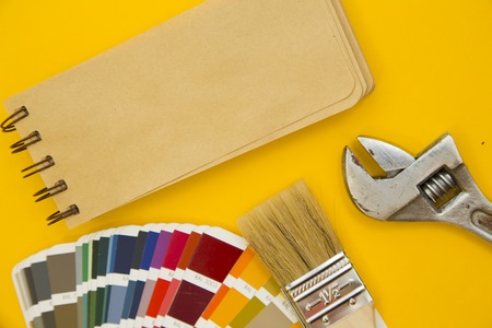 Repair and renovation concept. A set of tools for repair with brushes, color palette on a yellow...
