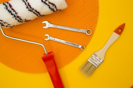 Repair and renovation concept. A set of tools for repair with brushes, screwdriver, gloves on a yellow background top view, flat lay, copy spaceの写真素材