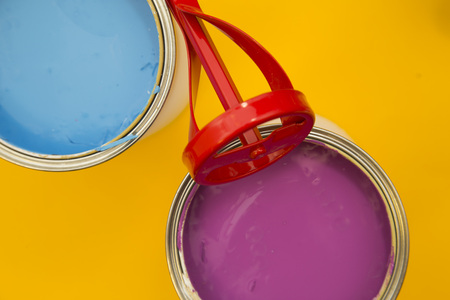 Repair and renovation concept. A set of tools for repair with cans of paint on a yellow background...