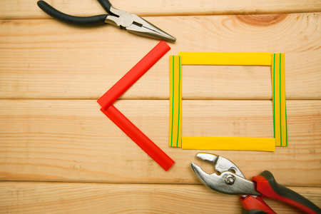 Repair carpenter tools: plairs and thermoplastic on white old wooden background, top view, copy spaceの写真素材