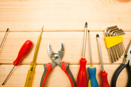 Repair carpenter tools: plairs and wrench on white old wooden background, top view, copy space