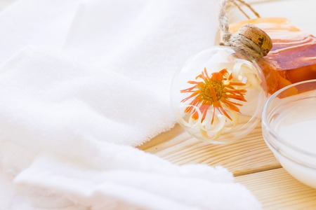 Spa and wellness setting with yellow flower, oil and soap on wooden white background closeupの写真素材