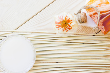Spa and wellness setting with yellow flower, oil and soap on wooden white background closeupの写真素材