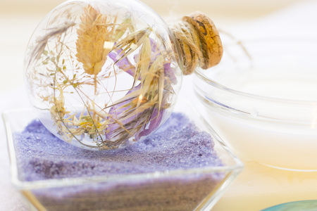 Spa and wellness setting with blue flowers, sea salt and soap on wooden white background closeup