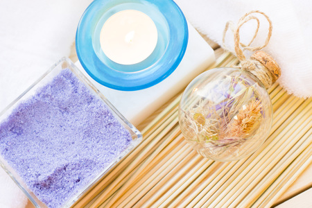 Spa and wellness setting with blue flowers, sea salt and soap on wooden white background closeup