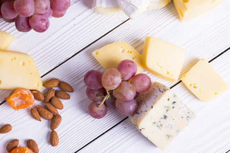 Cheese cuts with figs, nuts, honey, grapes on a wooden boards background. Top viewの写真素材
