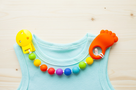 Baby yellow booties. Children's shoes and toys on white wooden boards background. Newborn. Top view