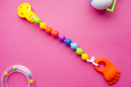 Baby yellow booties. Children's shoes and toys on pink background. Newborn. Top viewの写真素材