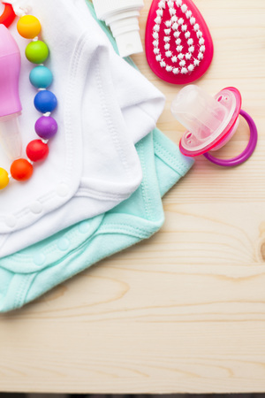 Baby yellow booties. Children's shoes and toys on white wooden boards background. Newborn. Top viewの写真素材