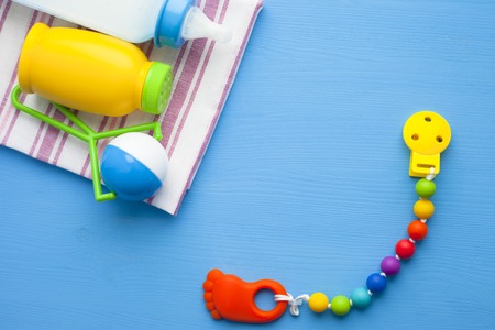 Baby yellow booties. Children's shoes and toys on blue background. Newborn. Top view