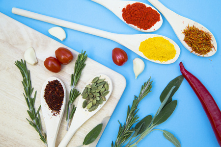 Cooking Hot Spicy Food Concept. Dry spices, beans and herbs in wooden spoons, chili pepper and...