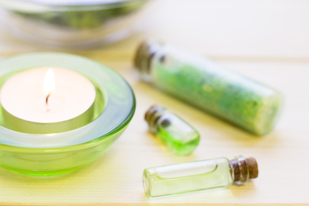 Cucumber home spa and hair care concept. Sliced cucumber, bottles of oil, jar of mask and a tea lightの写真素材