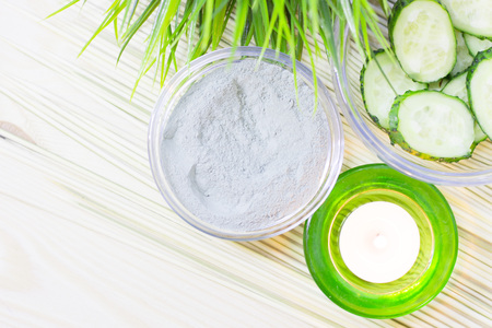 Cucumber home spa and hair care concept. Sliced cucumber, bottles of oil, candle , bathroom towel. Straw light background. Closeupの写真素材