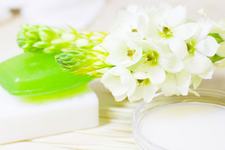 Cucumber home spa and hair care concept. Sliced cucumber, bottles of oil, green soap, bathroom towel. Straw light background. Closeupの写真素材