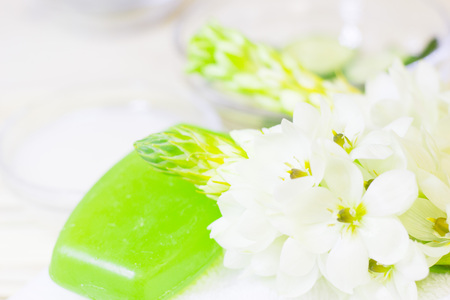 Cucumber home spa and hair care concept. Sliced cucumber, bottles of oil, green soap, bathroom towel. Straw light background. Closeupの写真素材