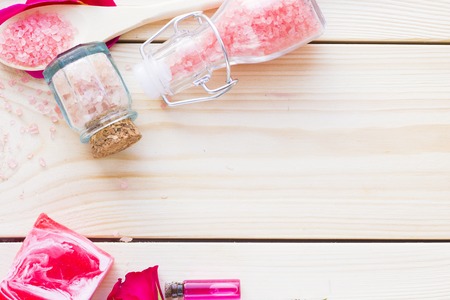 Spa and wellness setting with rose flower, sea salt, oil in a bottle on wooden old background closeupの写真素材
