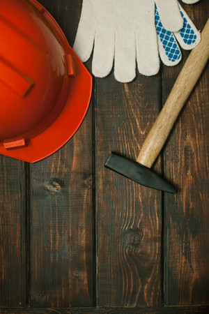 Repair modern tools: hummer and helmet on dark wooden background, top view, copy spaceの写真素材