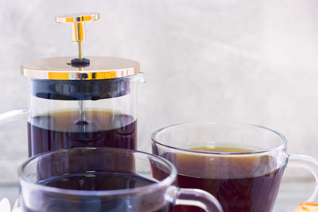 Black tea ceremony - waffles, glass full of tea, glass pot, tea leaves, sugar, yellow lemon, flower, spices on a wooden boards background. Top viewの写真素材