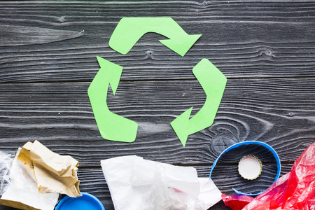 Environmental protection, ecology and recycling concept, recycle sign and garbage on dark wooden background top view closeupの写真素材