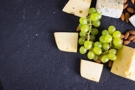 Snacks with wine - various types of cheeses, figs, nuts, honey, grapesの写真素材
