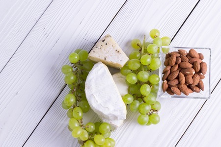 Snacks with wine - various types of cheeses, figs, nuts, honey, grapesの写真素材