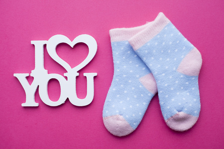 Newborn baby story. Socks and children's toys, scissors, baby bottle, nipple, hairbrush on red background. Top viewの写真素材