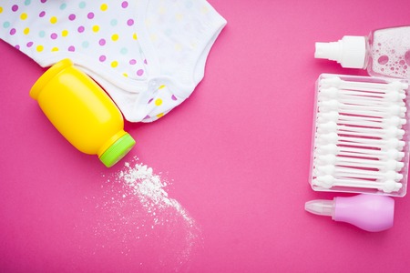 Newborn baby story. Towels and children's toys, scissors, baby bottle, nipple, hairbrush on red background. Top viewの写真素材