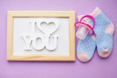 Newborn baby story. Frame with copyspace and children's toys, scissors, baby bottle, nipple,...