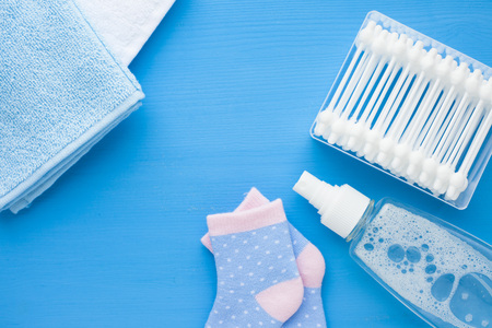 Newborn baby story. Towels and children's toys, scissors, baby bottle, nipple, hairbrush on blue background. Top viewの写真素材