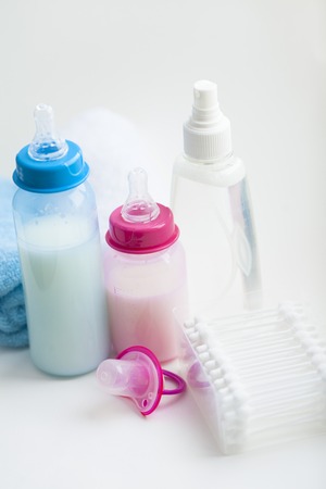 Newborn baby story. Towels and children's toys, scissors, baby bottle, nipple, hairbrush on white background. Top viewの写真素材