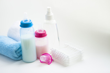 Newborn baby story. Towels and children's toys, scissors, baby bottle, nipple, hairbrush on white background. Top viewの写真素材