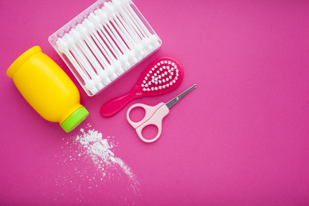 Newborn baby story. Children's toys, scissors, baby bottle, nipple, hairbrush on purple background. Top viewの写真素材
