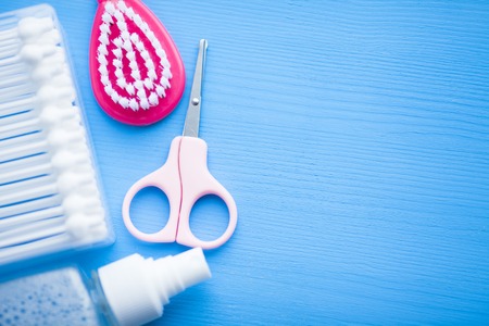 Newborn baby story. Children's toys, scissors, baby bottle, nipple, hairbrush on blue background. Top viewの写真素材