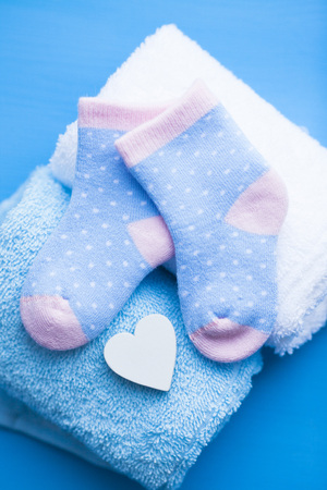Newborn baby story. Towels and children's toys, scissors, baby bottle, nipple, hairbrush on blue background. Top viewの写真素材