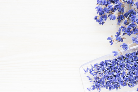 Spa and wellness setting with lavender flowers, sea salt, oil in a bottle, aroma candle on wooden white background closeupの写真素材