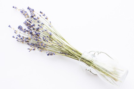 Spa and wellness setting with lavender flowers, sea salt, oil in a bottle, aroma candle on wooden white background closeupの写真素材