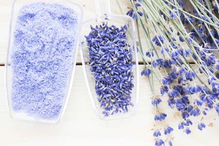 Spa and wellness setting with lavender flowers, sea salt, oil in a bottle, aroma candle on wooden white background closeupの写真素材