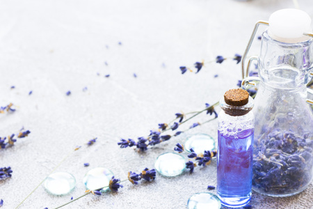 Spa and wellness setting with lavender flowers, sea salt, oil in a bottle, aroma candle on wooden white background closeupの写真素材