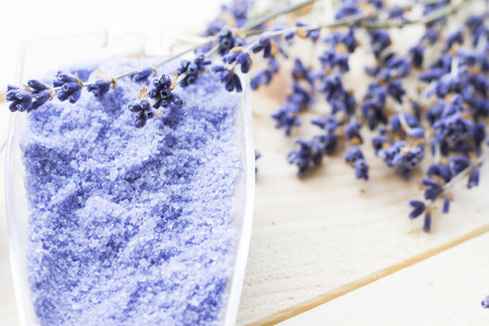 Spa and wellness setting with lavender flowers, sea salt, oil in a bottle, aroma candle on wooden white background closeupの写真素材