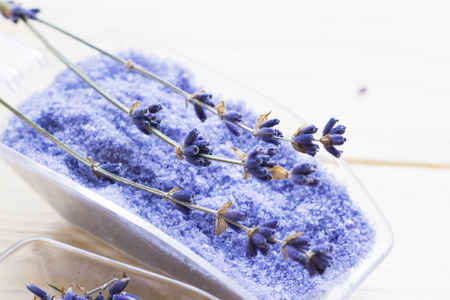 Spa and wellness setting with lavender flowers, sea salt, oil in a bottle, aroma candle on wooden white background closeupの写真素材