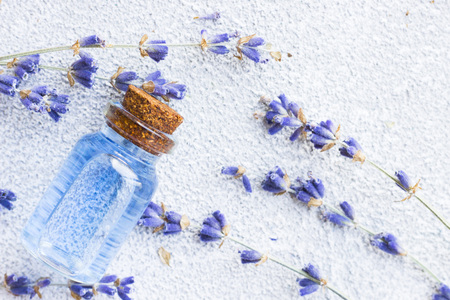 Spa and wellness setting with lavender flowers, sea salt, oil in a bottle, aroma candle on wooden white background closeupの写真素材