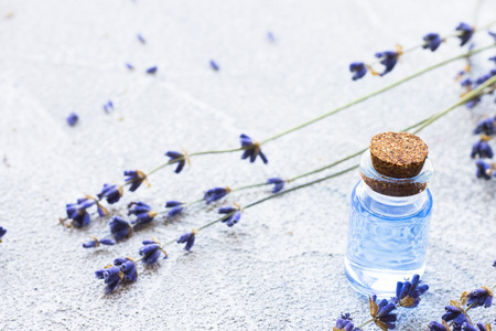 Spa and wellness setting with lavender flowers, sea salt, oil in a bottle, aroma candle on wooden white background closeupの写真素材